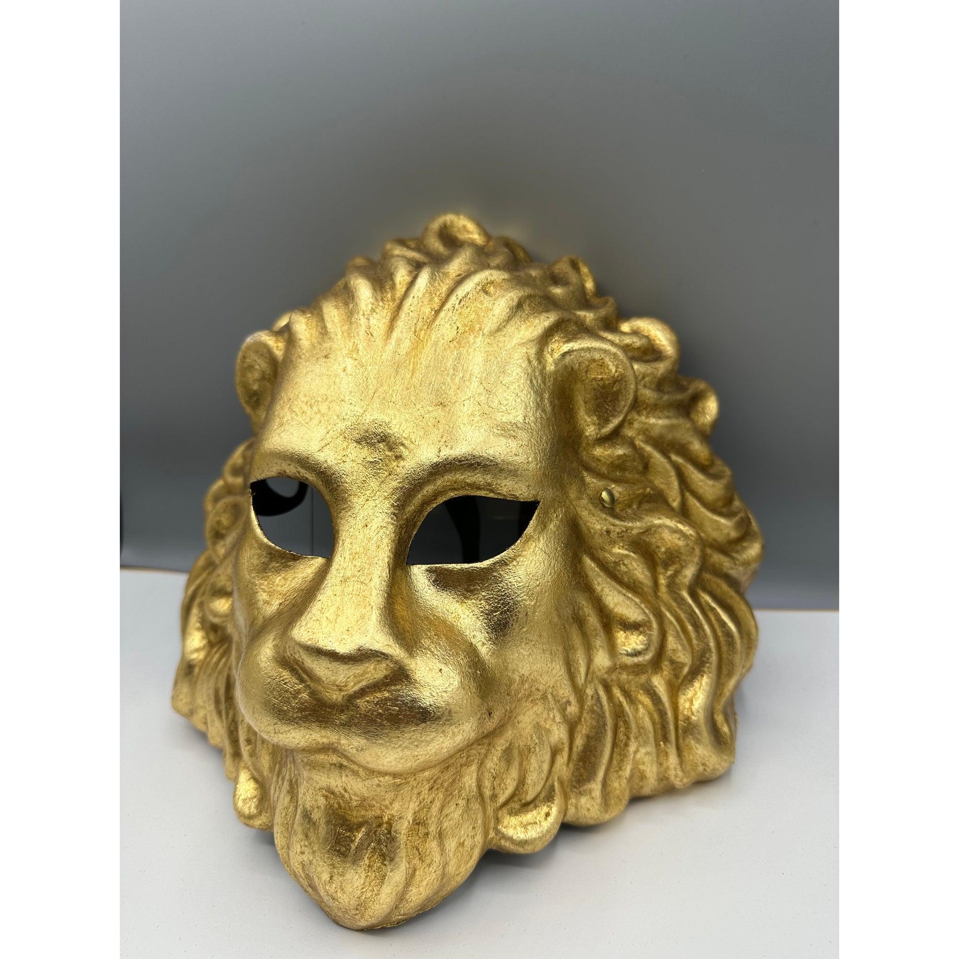 Handcrafted gold lion mask with textured mane