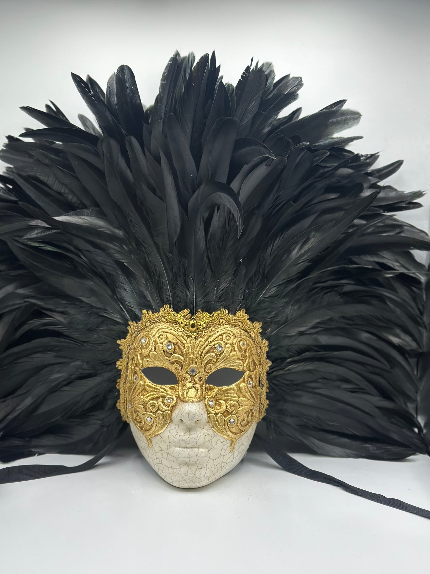 Gouden gezichtsmasker met veren