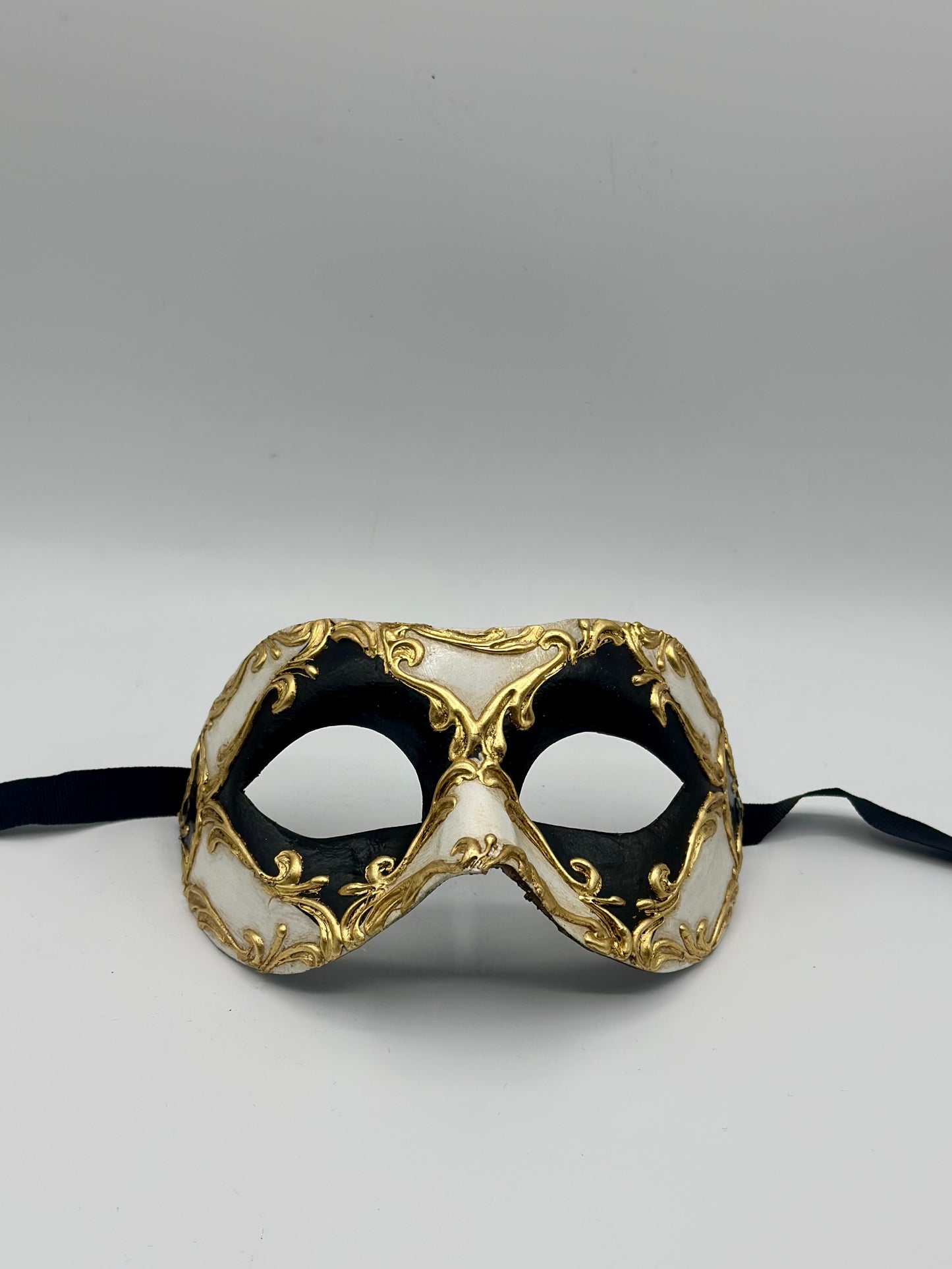 Schwarz-weiße venezianische Maske mit goldenen Barockdetails